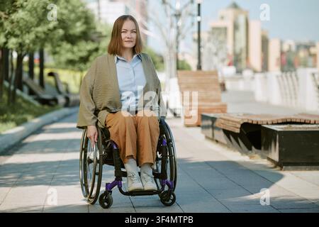Portrait of Young Adult Woman with Disability Using Wheelchair Outdoors Stock Photo