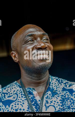 Smiling man in patterned shirt looks upward, Ghana Stock Photo