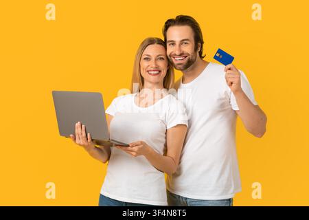 Happy Caucasian Couple Using Laptop And Holding Credit Card, Business Concept Stock Photo