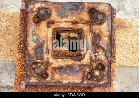 Close-up Top View of Heavily Corroded Remnant Street Lamp Base on Coastal Balustrade Stock Photo