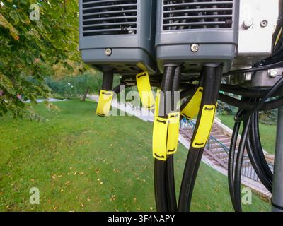 Close-up of outdoor telecommunication equipment with yellow cable ties and green grass background Stock Photo