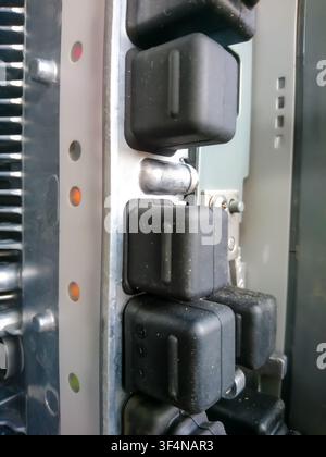 Detailed view of electronic components, showing status LEDs and protective rubber casings on a server rack or industrial machine Stock Photo