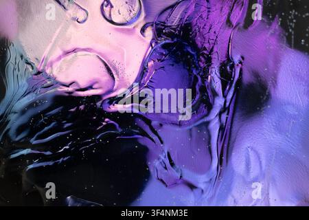 Abstract liquid surface showing flowing movement with shades of purple and violet Stock Photo