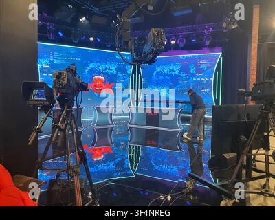 Interior of a television studio set up for a cooking competition or game show. Three contestant podiums with digital score displays reading '000' are Stock Photo