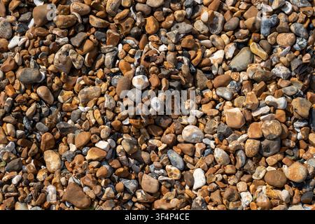 Top-down view of sea pebbles and small stones on a beach texture. Stock Photo