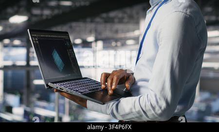 Server hub coworkers visualizing large language model architecture using notebook. Data center technicians on industrial platform collaborating on neural network software tasks using laptop Stock Photo
