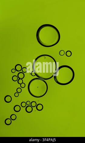Oil bubbles floating in green liquid, forming an abstract organic pattern Stock Photo