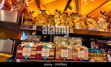 MILAN, ITALY - MAY 18, 2024: Decorative gift boxes and bags of Italian chocolate truffles arranged neatly on store display shelves. Stock Photo