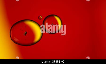 Oil droplets and bubbles suspended in red and yellow liquid Stock Photo
