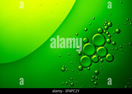 Green oil bubbles creating an abstract pattern in a fluid background Stock Photo
