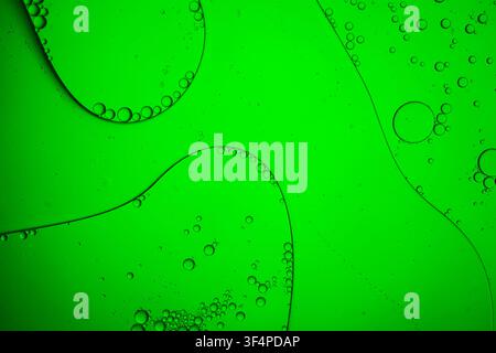Green oil and water creating an abstract macro liquid texture with bubbles and reflections Stock Photo