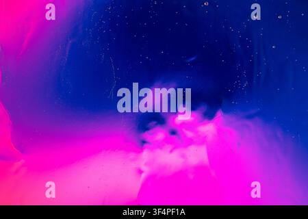 Abstract blue and magenta liquid forms a vibrant, cosmic background with small bubbles Stock Photo