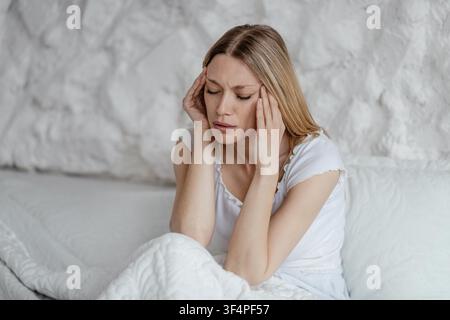 Worried Young Caucasian Woman Holding Head At Home, Mental Health Concept Stock Photo