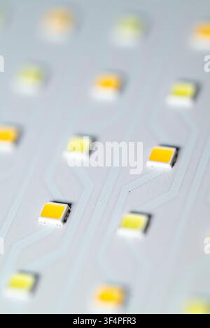 Extreme macro shot of surface mount yellow led diodes aligned on a white circuit board Stock Photo