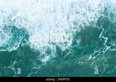 Abstract natural background showing the chaotic movement of white sea foam over dark ocean water Stock Photo