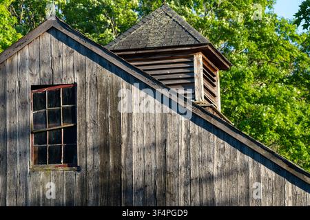 Weathered Wooden Barn with Cupola and Old Window in Summer Light Stock Photo