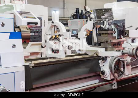 Industrial lathe machine bed equipped with two heavy-duty steady rests for supporting long workpieces during turning. The setup features precision gui Stock Photo