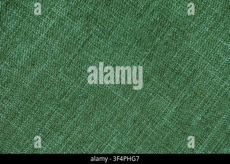 Green woven fabric texture photographed in close-up, ideal as a seamless-looking textile background. Stock Photo