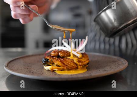 Delicate Sauce Drizzled Over Gourmet Dish in Elegant Dining Setting Stock Photo
