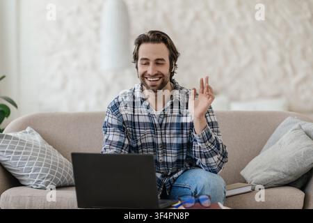 Smiling Young Caucasian Man Having Online Video Call At Home, Business Concept Stock Photo