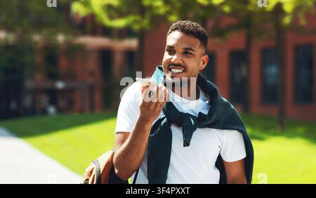 Smiling African American Man Talking On Smartphone With Hands Free Device Outdoors Stock Photo
