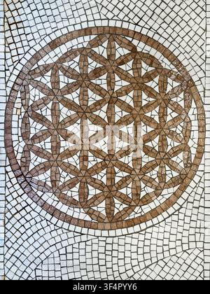 Decorative stone mosaic embedded in the historic pavement of Nice Old Town, featuring a traditional geometric pattern inspired by Mediterranean design Stock Photo