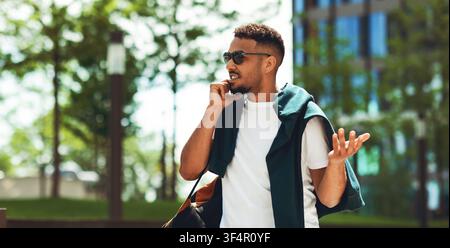Young Man Talking On Phone With Expression Outdoors, Business Concept Stock Photo