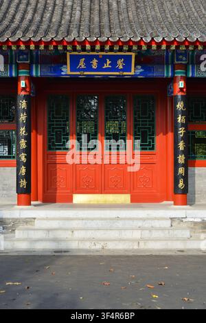 Traditional Chinese imperial study hall of Qing Dynasty,with red walls, grey tiled roof,and colorful painted eaves.Blue plaque with golden characters. Stock Photo