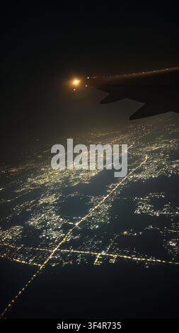 Aerial night view of city lights from airplane window Stock Photo