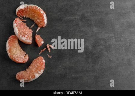 Peeled Pomelo Fruit on Black Cement Table, Isolated with Copys Space for Text. Top View. Stock Photo