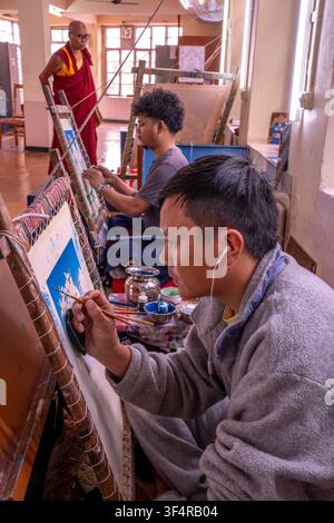 Norbulingka Institute, Sidhpur, Himachal Pradesh, India. A monk watches students painting thangkas in a traditional workshop. Craftsmanship is an impo Stock Photo