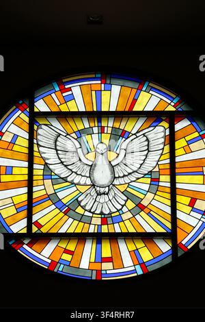 Marian Shrine of Nui Cui. A stained-glass window depicting the dove of the Holy Spirit, a symbol of peace and divine light in Christian sacred art. Th Stock Photo