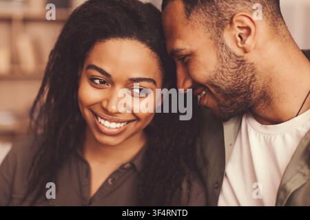 Happy African American Woman And Man Smiling Together At Home, Love And Bonding Concept Stock Photo