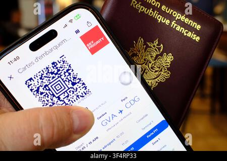 A digital boarding pass on a smartphone, along with a French passport, illustrates the process of preparing for a flight with the Sky Priority program Stock Photo