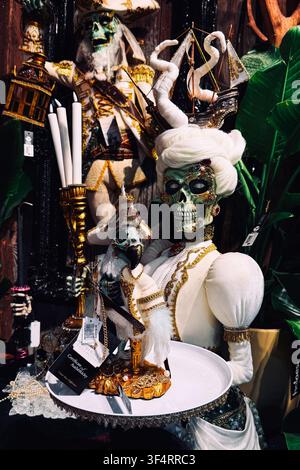 Skeleton figure in elaborate costume holding a small skull. gothic luxury decor, vintage Halloween display, elaborate costume design. Warsaw, Poland Stock Photo