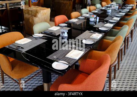 An elegantly set restaurant table with cutlery, plates, and napkins, ready to welcome guests for a meal. Hoa Lu, Vietnam. Hoa Lu, Vietnam. Stock Photo
