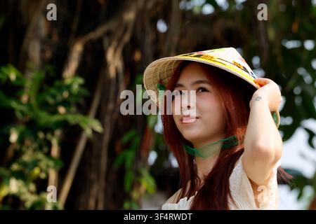 Hoa Lu, Vietnam. A young woman wearing a traditional conical hat, a cultural symbol of Vietnam. Stock Photo