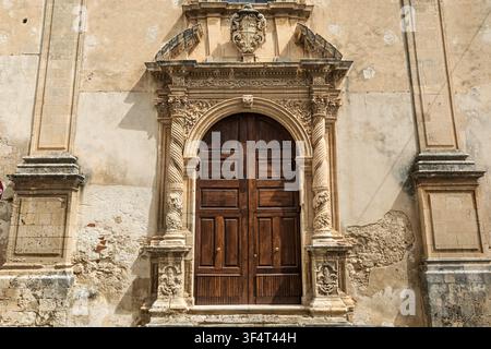 Baroque arched wooden doorway with solomonic columns  of a palazzio or church in via Vicere Speciale, Noto, Sicily, Italy Stock Photo