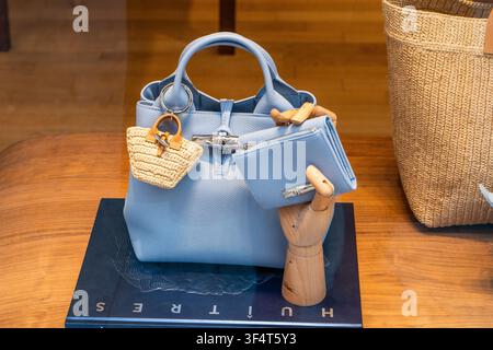 Longchamp Light Blue Leather Handbag with a Mini Woven Basket Charm, Wallet and Wooden Hand Display in store shop on street. Verona, Italy - June 25, 2026 Stock Photo