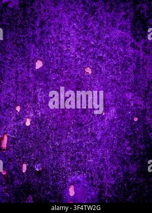 Abstract textured surface in deep purple and magenta hues with weathered spots, speckles, and uneven patterns. Stock Photo