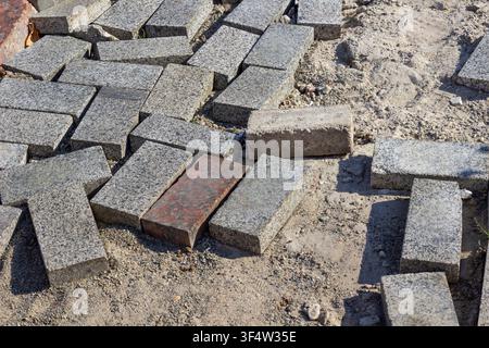 Gray granite tiles lie on the ground. Walkway repairs. Top View. Stock Photo