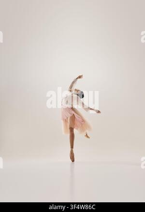 Graceful ballerina curving body in lyrical pose while balancing en pointe Stock Photo