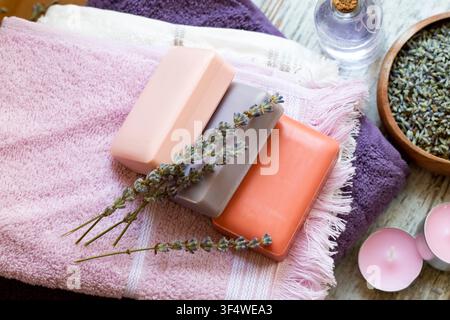 Top view of handmade natural lavender soap bars with dry lavender flowers towels and candles Stock Photo