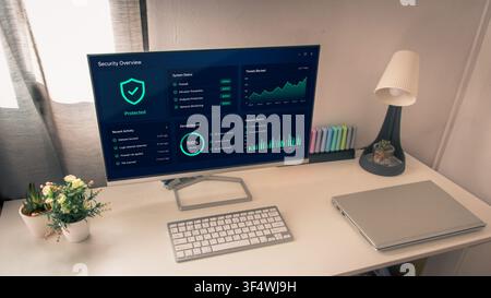 Wide home office scene with a monitor displaying a protected cybersecurity overview, keyboard, plants, lamp and a closed laptop on a white desk. Stock Photo