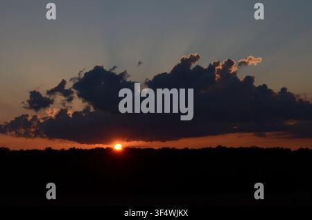 Sunset through Cumulus Clouds Stock Photo