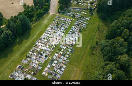 Aerial view of the cemetery featuring rows of gravestones set within a grassy field surrounded by dense green forest in Juzintai, Panevezys County, Li Stock Photo