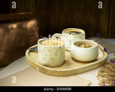 Coffee and sweet snack served on a wooden tray in a cozy cafe Stock Photo