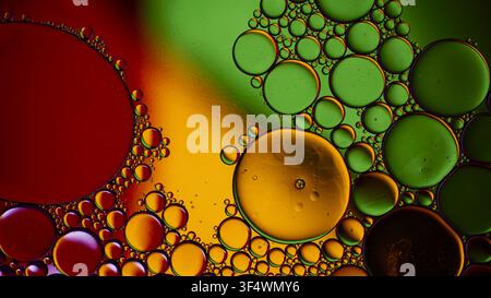 Oil and water creating vibrant abstract bubbles with green, red, and yellow colors Stock Photo
