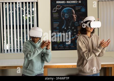 African American youths wearing hoodies and VR headsets interacting with AI poster at lab bench Stock Photo