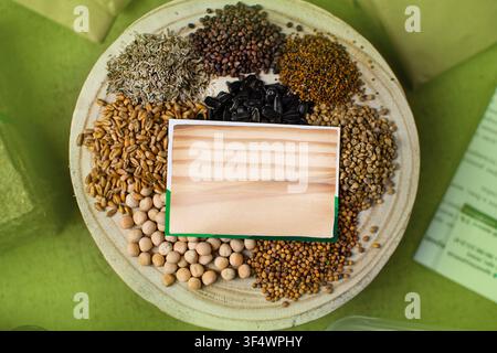Microgreens seed variety on plate with sunflower pea wheat and mustard seeds on green background. Growing microgreens at home. Flat lay seed variety p Stock Photo